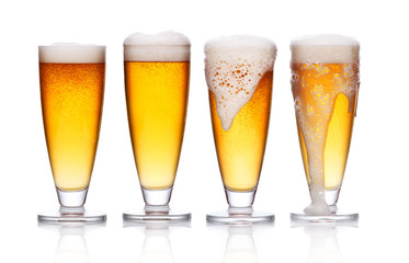 set of frosty glass of light beer with foam on white 