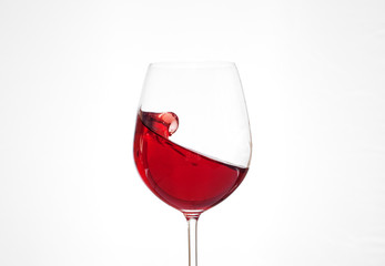 Red wine in a glass on a white background. The concept of beverages and alcohol.