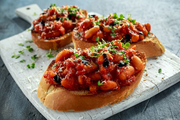 Beans fried in tomato sauce on toasted bread with cross salad sprinkle