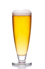 glass of cold light beer with foam on white .
