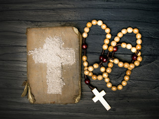Old Bible, rosary and Cross of ash - symbols of Ash Wednesday.