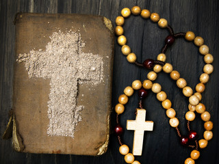 Old Bible, rosary and Cross of ash - symbols of Ash Wednesday.