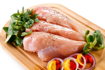 Raw chicken breasts on cutting board 