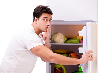 Fototapeta premium Man next to fridge full of food