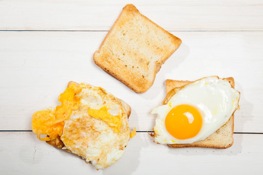 Toasts and egg on a white wooden table