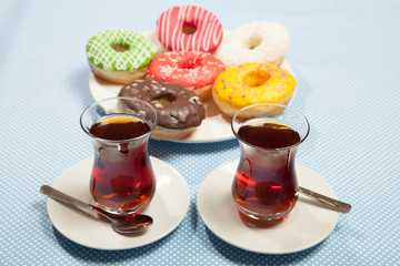 cups of tea and a donut on a blue table