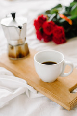 A cup of coffee, coffee on the wooden Boards, a bouquet of red roses on a white background