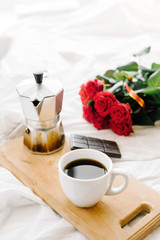 A cup of coffee, coffee on the wooden Boards, a bouquet of red roses on a white background