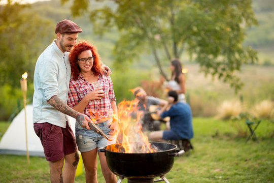 Pair in love drinking beer and prepare grill fire