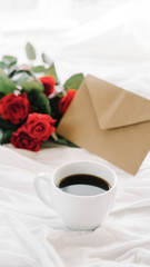 cup of coffee and a bouquet of red roses, envelope