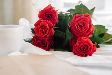 cup of coffee and a bouquet of red roses, envelope