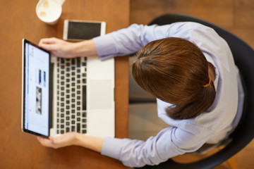 Top view portrait of a beautiful woman using laptop on the wooden table