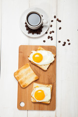 cup of coffee, toast and egg on a white wooden table
