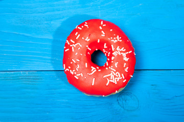 Obraz na płótnie Canvas Doughnut on blue wooden table