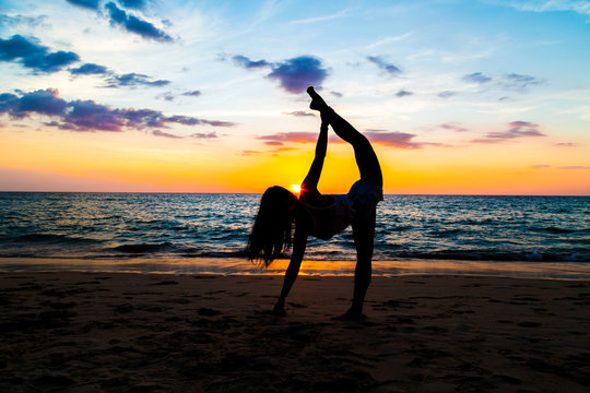 Silhouette sport woman stand yoga on the sea beach
