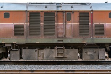 lateral of Old Red diesel electric locomotive on railway - freight train at station 