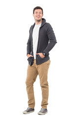 Fototapeta premium Happy smiling casual man wearing sweater jacket with hands in pockets looking back. Full body length portrait isolated over white background.