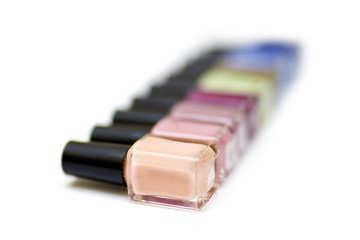 Coloured nail polish bottles on a white background