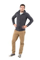Fototapeta premium Confident young handsome casual man wearing zipper sweater with hands on hips. Full body length portrait isolated over white background.