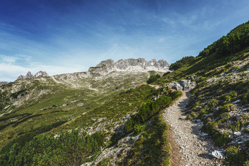 Naklejka na ściany i meble Trekking trail through rugged alpine scenery