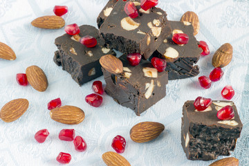 Homemade nut fudge with almond and pomegranate seeds on light cloth napkin