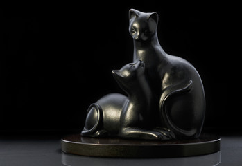figurine two black cats on black background
