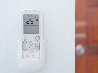 Remote control of air conditioning on Cement wall.(twenty-five degree Celsius).