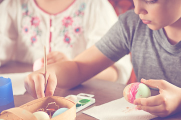 Boy and girl paint eggs, holy Easter