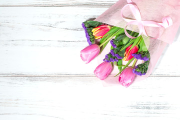 Bouquet of tulips on a white wooden background with text space