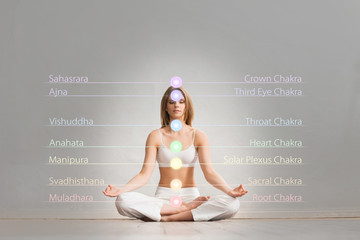 Woman meditating in lotus position. Colored chakra lights over her body. Yoga, zen, Buddhism,...