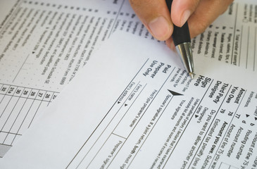 Fototapeta premium Hand hold pen on sign point on the tax forms paper in business concept