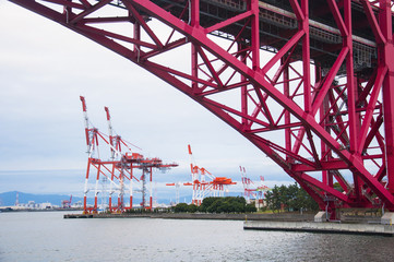 Commercial delivery cargo container ship being unloaded in the harbor transportation concept