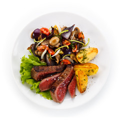 Steaks, baked potatoes and vegetable salad