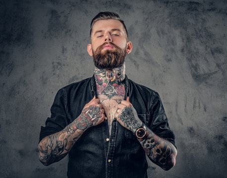 Studio portrait of bearded hipster man with tattoos.