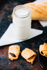 Bottle of milk with the fresh bakery over rustic surface.
