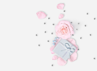 March 8th. International Woman's day. Pink rose, petals and gift. Flat lay