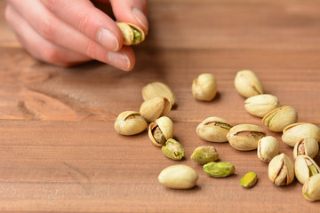 Pistachio nuts on wooden background. Selective focus.