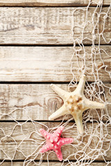 Fishing net with starfish on wooden table