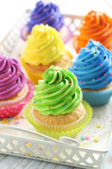 Tasty cupcakes in tray on a white wooden table