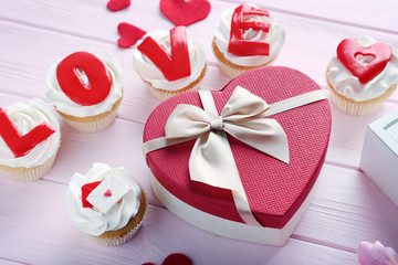 Tasty cupcakes on a pink wooden table