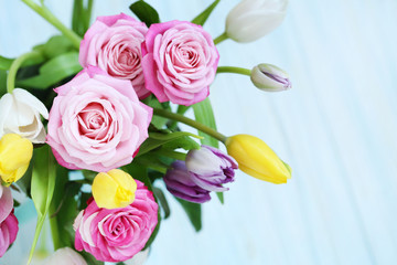 Bouquet of beautiful roses and tulips on mint background