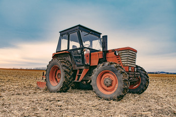 Tractor working on the farm, agricultural transport, a farmer working in the field, tractor at sunset, old tractor closeup