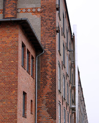 Hohe Hausfassade mit einem Edelstahlschornstein.