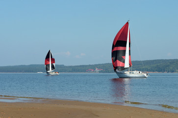 Fototapeta premium Sailing boats on the river, the reflection on water in the distance shore.