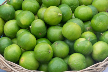 Pile of Green Fresh Lemons in a basket