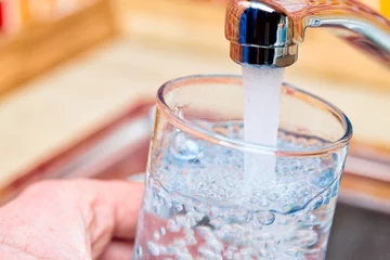 Fotobehang Een glas vullen met drinkwater uit de keukenkraan © Dmitry Naumov