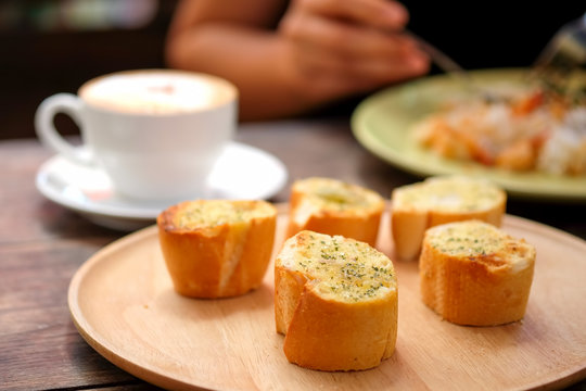 Garlic bread on wood plate.