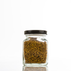 Close up jar of bee pollen isolated on white background.