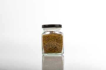 Close up jar of bee pollen isolated on white background.