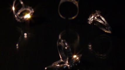 Various Pieces Of Jewelry Fall On Black Reflective Surface, Super Slow Motion. - Powered by Adobe